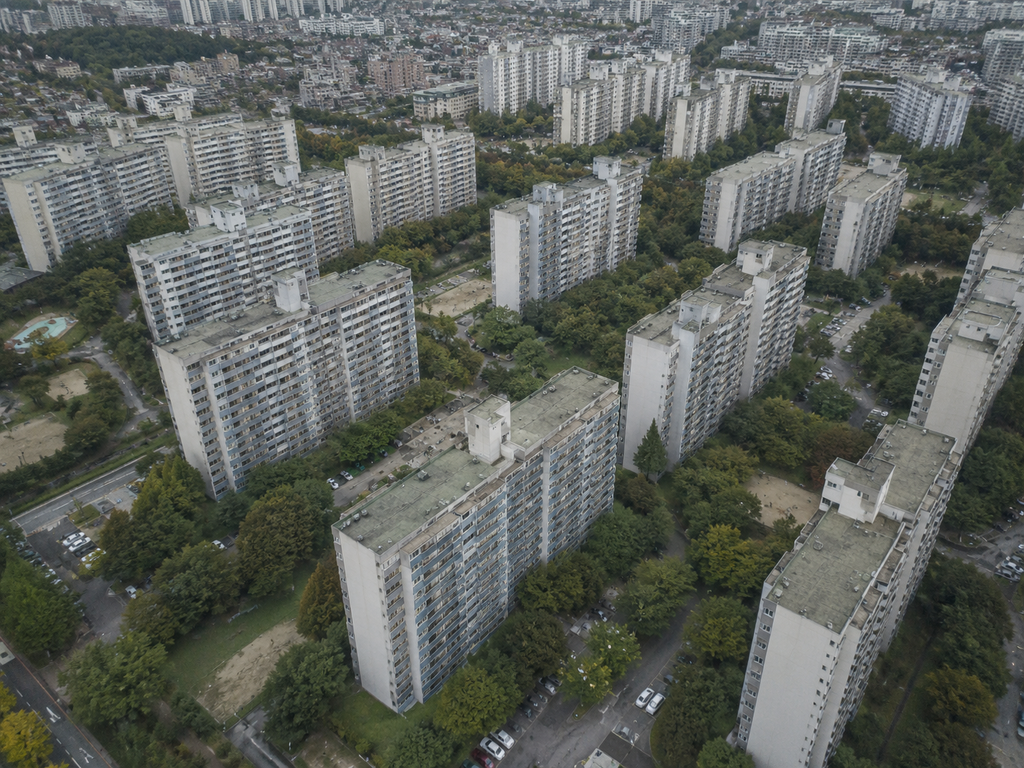Aerial view of a Korean apartment complex with repeating residential buildings, roads, and green spaces