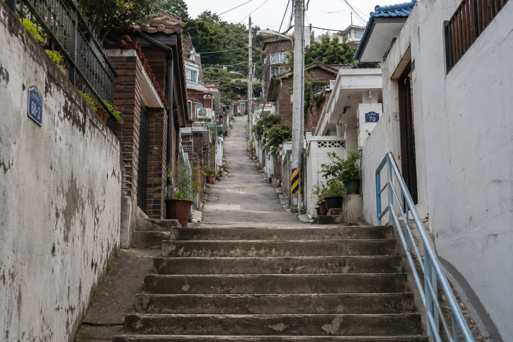 In some neighborhoods around the Seoul City Wall, steep paths and low-rise housing remain closely tied to the contours of the hills.