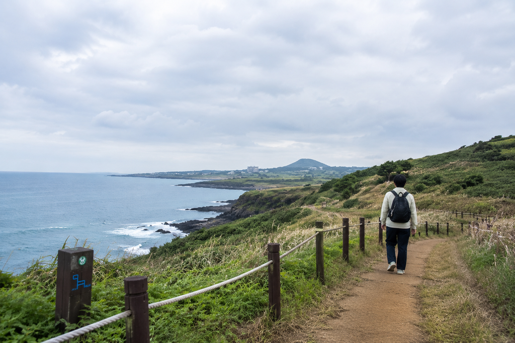 Solo traveller walking along the Jeju Olle Trail